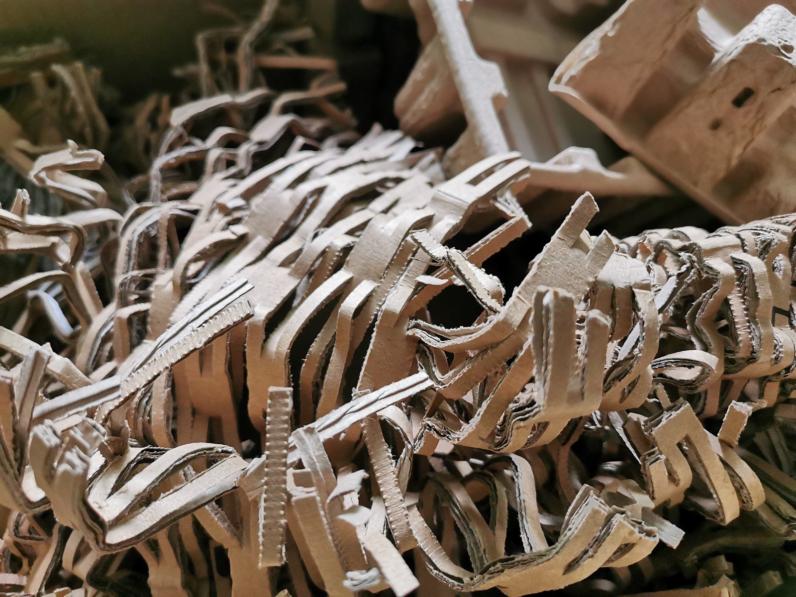 Sure, here is a detailed alt text description for the image at the provided URL:

"Image of a pile of brown shredded paper. The shredded paper consists of uniformly thin strips, giving it a textured, crinkled appearance. The paper is light brown in colour, resembling the natural hue of cardboard or kraft paper. The strands of paper are intertwined, creating a somewhat chaotic and dense mound. The lighting is natural, highlighting the different shades of brown and the intricate shadows formed by the criss-crossing strips. The photograph captures the material in high detail, allowing the viewer to distinguish the individual pieces of shredded paper and the overall volume they create when amassed together."

I hope this helps!